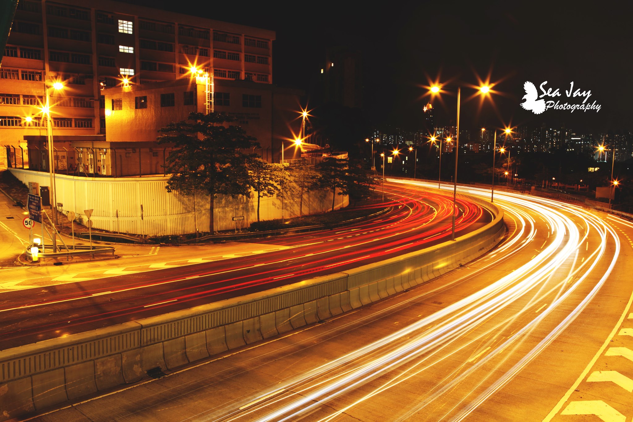 Long exposure of golden light trails along a city road at night